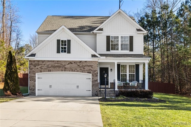 view of front of property featuring a garage, covered porch, and a front lawn