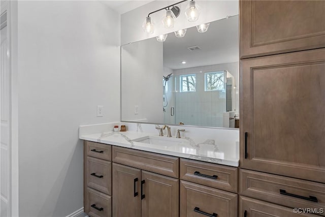 bathroom with a shower stall, visible vents, and vanity