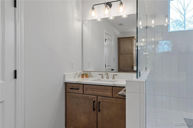 bathroom with a stall shower, visible vents, and vanity