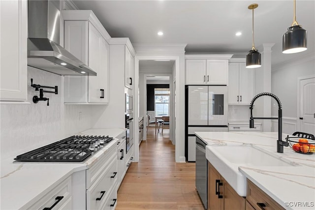 kitchen featuring wall chimney exhaust hood, white cabinetry, and stainless steel appliances