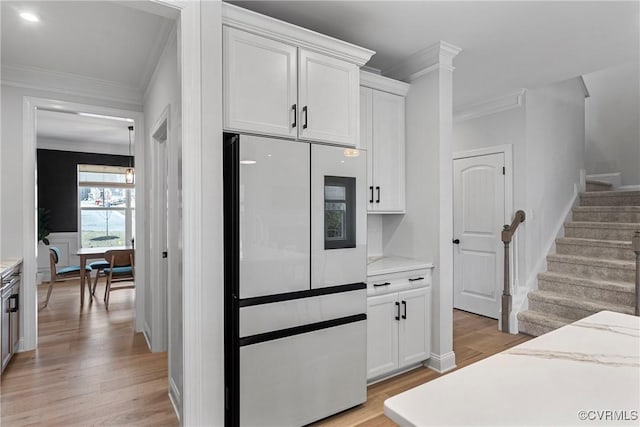 kitchen with refrigerator with glass door, light wood-type flooring, white cabinets, and crown molding