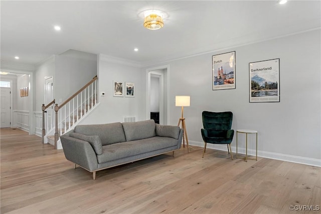 living area with light wood finished floors, stairway, crown molding, and recessed lighting