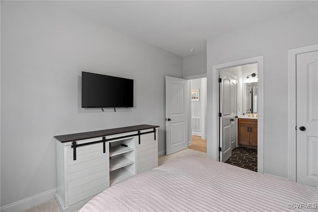 bedroom with baseboards and ensuite bathroom