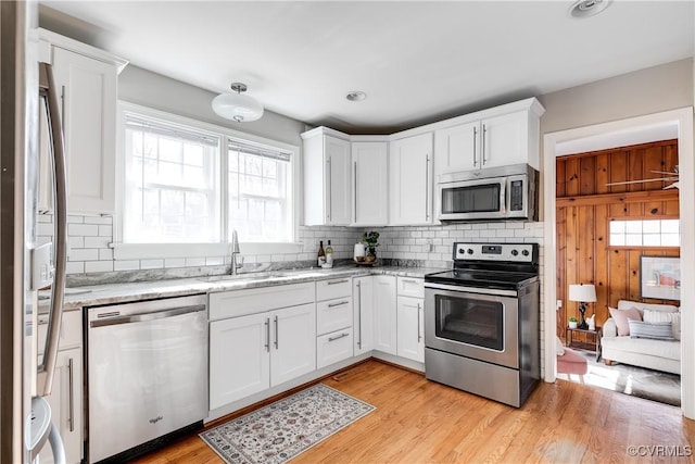 kitchen featuring appliances with stainless steel finishes, sink, white cabinets, and light hardwood / wood-style flooring