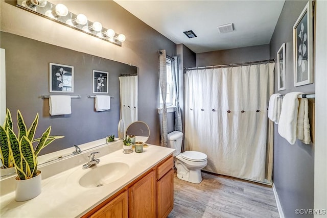 bathroom with vanity, hardwood / wood-style floors, and toilet