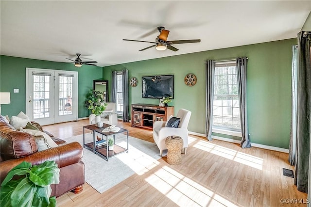 living room with ceiling fan and light wood-type flooring