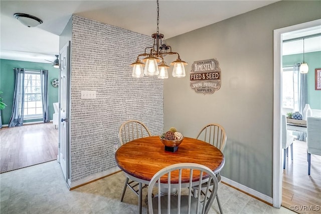 dining room with ceiling fan and brick wall