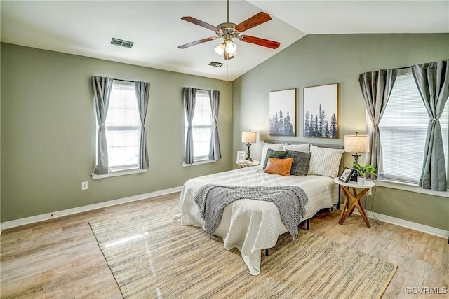 bedroom with ceiling fan, lofted ceiling, and light wood-type flooring