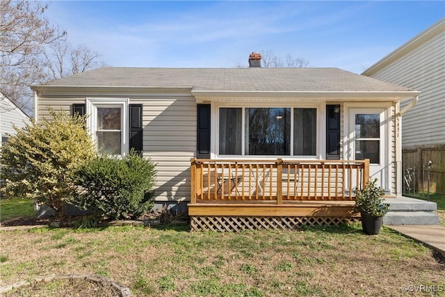 view of front facade with a front lawn and a deck