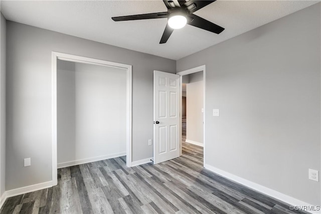 unfurnished bedroom with wood-type flooring, a closet, and ceiling fan