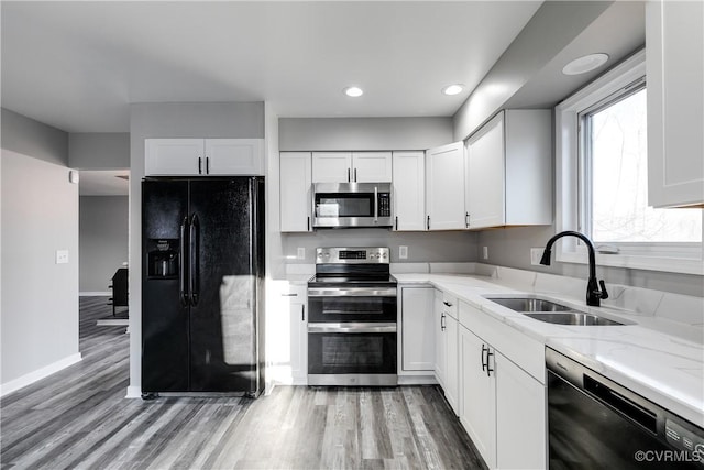 kitchen featuring white cabinetry, light stone countertops, sink, and black appliances