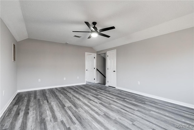 unfurnished bedroom with hardwood / wood-style flooring, ceiling fan, lofted ceiling, and a textured ceiling