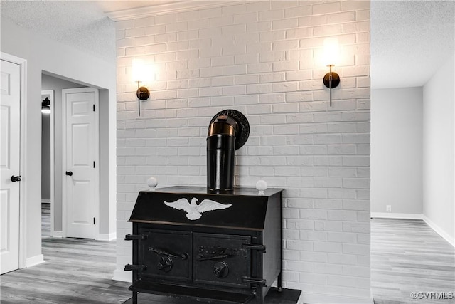 room details featuring wood-type flooring, a textured ceiling, and a wood stove