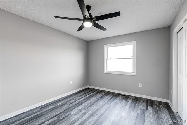 unfurnished bedroom featuring ceiling fan, dark hardwood / wood-style floors, a textured ceiling, and a closet