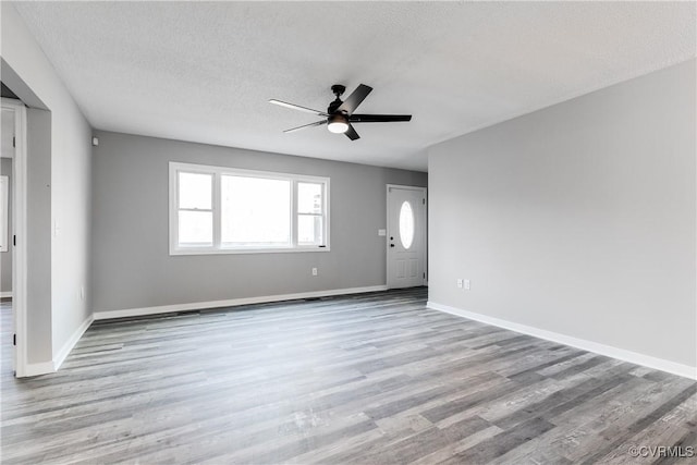 unfurnished room with ceiling fan, light hardwood / wood-style flooring, and a textured ceiling