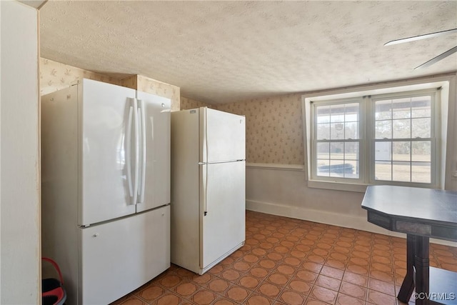 kitchen featuring a textured ceiling and white fridge