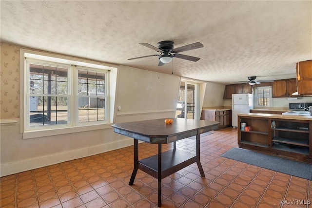 dining room with ceiling fan and a textured ceiling