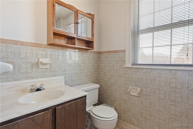 bathroom with vanity, tile walls, and toilet