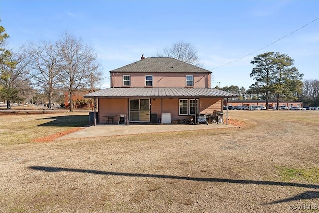 back of house featuring a lawn and a patio