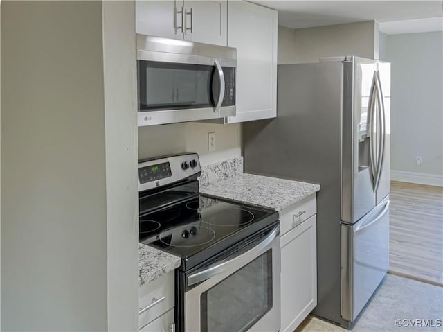 kitchen featuring light stone countertops, white cabinets, and appliances with stainless steel finishes