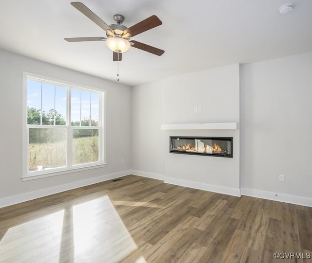 unfurnished living room with wood-type flooring and ceiling fan