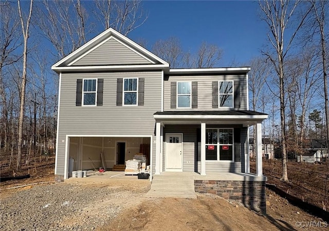 traditional-style home featuring a porch and an attached garage