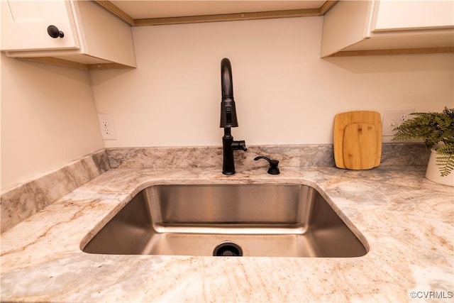 details featuring light stone countertops and sink