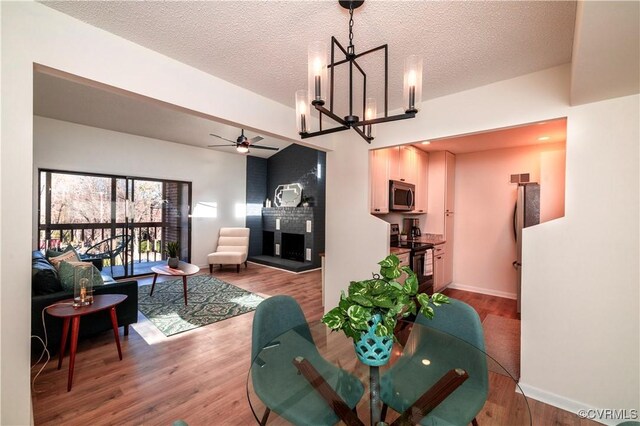 living room with wood-type flooring, a textured ceiling, and a fireplace