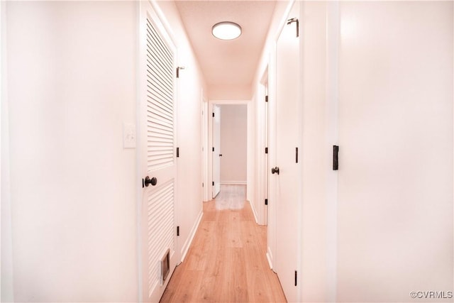 hallway with light hardwood / wood-style floors