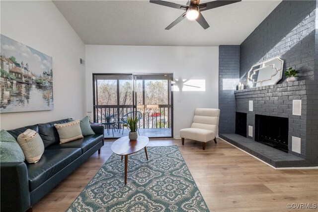 living room featuring hardwood / wood-style floors, a fireplace, and ceiling fan