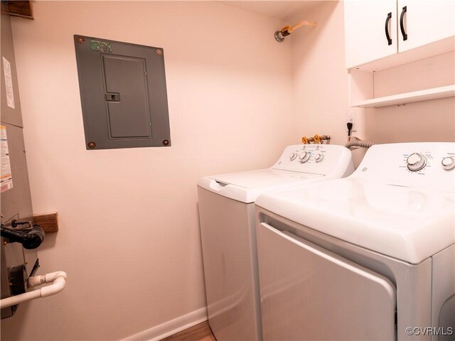 laundry room featuring cabinets, washer and dryer, and electric panel