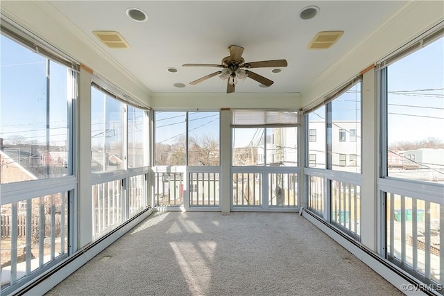 unfurnished sunroom with a baseboard radiator, ceiling fan, and plenty of natural light