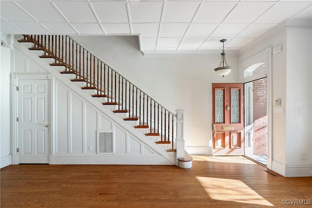 entryway featuring crown molding, wood-type flooring, and a drop ceiling