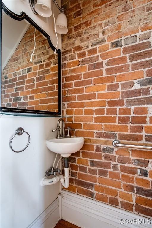 bathroom with brick wall and sink