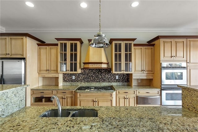 kitchen featuring pendant lighting, sink, custom exhaust hood, ornamental molding, and stainless steel appliances