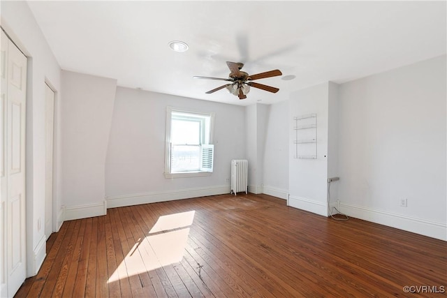 spare room featuring radiator heating unit, dark hardwood / wood-style floors, and ceiling fan