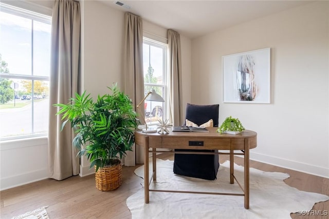 home office with light hardwood / wood-style flooring