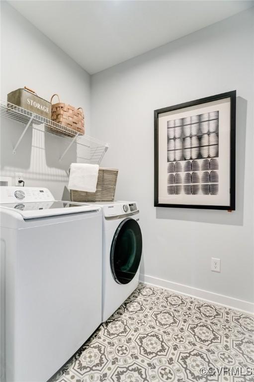 clothes washing area with independent washer and dryer and light tile patterned floors