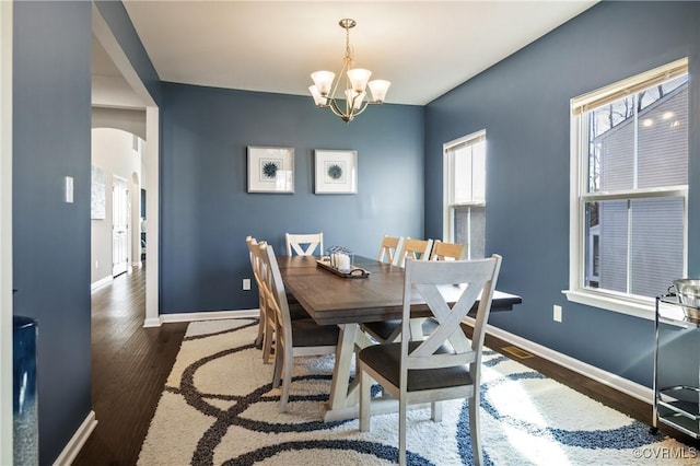 dining area with dark hardwood / wood-style floors and a chandelier