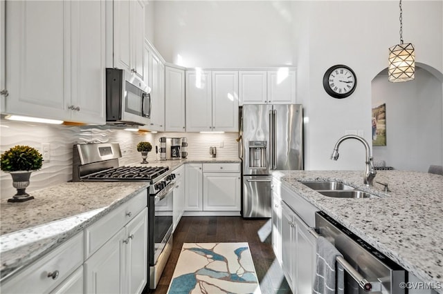 kitchen featuring pendant lighting, sink, stainless steel appliances, and white cabinets