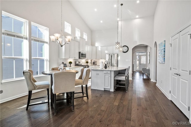 dining area with an inviting chandelier, dark wood-type flooring, and plenty of natural light