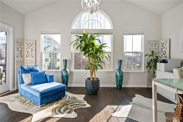 living area featuring lofted ceiling, dark hardwood / wood-style floors, and a chandelier