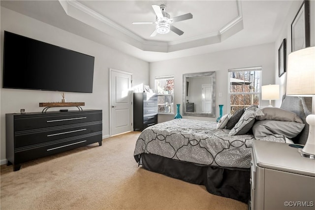 bedroom with ceiling fan, ornamental molding, a tray ceiling, and light carpet