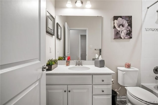 full bathroom featuring tiled shower / bath combo, vanity, and toilet