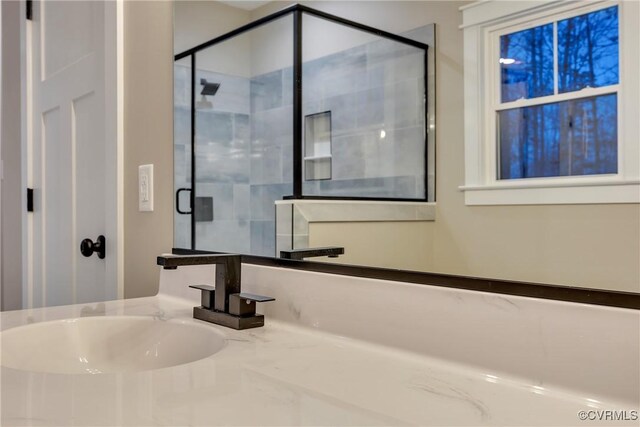 bathroom featuring an enclosed shower and sink