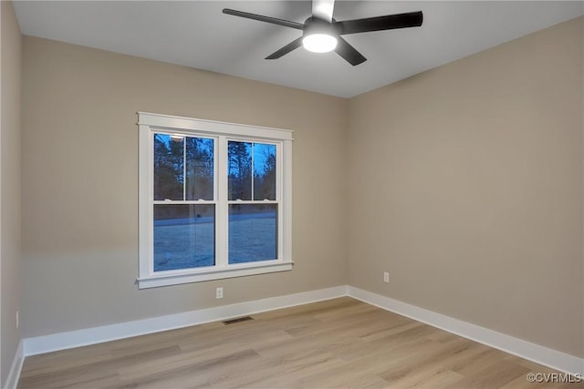 unfurnished room featuring baseboards, visible vents, light wood-style floors, and ceiling fan