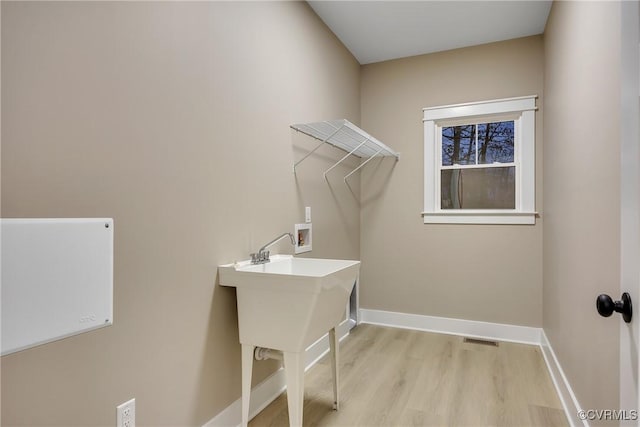 washroom with hookup for a washing machine, baseboards, light wood finished floors, visible vents, and laundry area