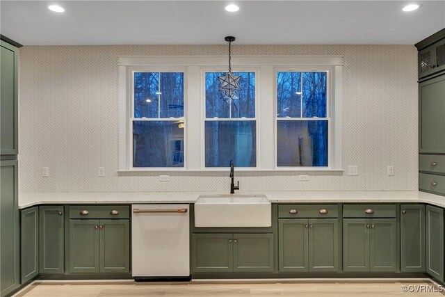 kitchen with decorative light fixtures, dishwasher, sink, decorative backsplash, and green cabinetry