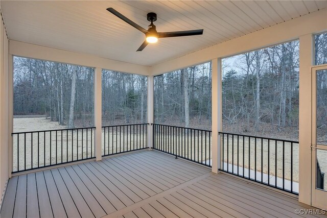 unfurnished sunroom with ceiling fan