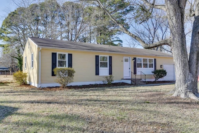 single story home featuring a garage and a front lawn